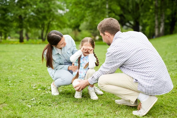 公園で寒さの間に彼らの悲しい小さな娘をサポート若いお父さんとお母さん — ストック写真