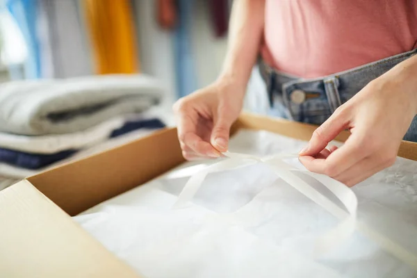 Zeitgenössischer Designer Bindet Weißes Band Über Verpackte Und Gefaltete Kleidung — Stockfoto