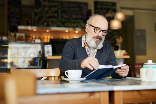 Hombre Barbudo Mayor Sentado Cafetería Volteando Página Del Cuaderno Libro —  Fotos de Stock