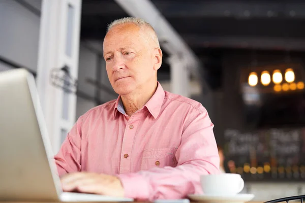 Poważny Człowiek Dojrzały Różowej Koszuli Siedzi Przed Laptop Czytanie Danych — Zdjęcie stockowe