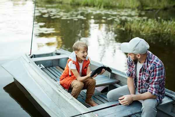 Joyeux Garçon Montrant Son Père Gros Poisson Attrapé Assis Parlant — Photo