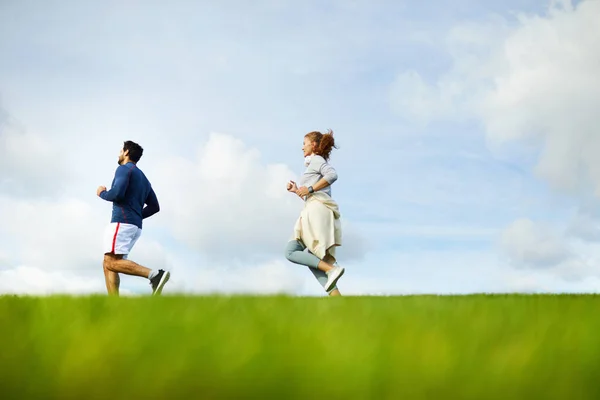 Aktywna Para Jogging Zielonym Polu Korzystających Ich Treningu Świeżym Powietrzu — Zdjęcie stockowe