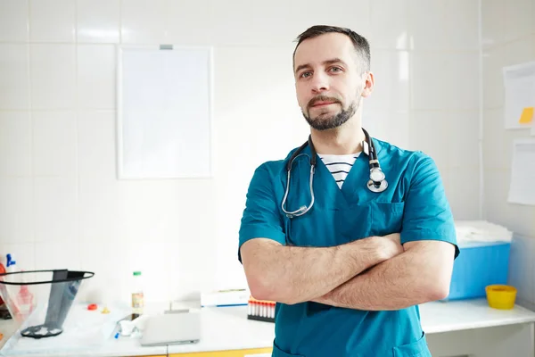 Joven Doctor Uniforme Cruzando Los Brazos Pecho Mientras Mira Oficina —  Fotos de Stock