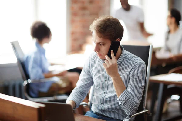 Ung Affärsman Avslappnad Klädsel Sitter Vid Bordet Och Pratar Mobiltelefon — Stockfoto