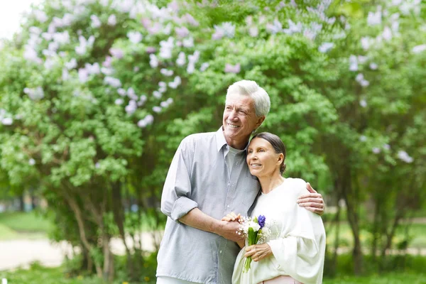 Alegre Cariñosa Pareja Ancianos Disfrutando Paseo Por Floreciente Parque Entre —  Fotos de Stock