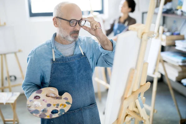 Confused Mature Painter Color Palette Looking Sketch Easel Eyeglasses — Stock Photo, Image