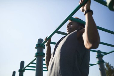 Pull-up egzersiz performans papatyanın kas siyah yakışıklı genç güçlü olmak için bar, açık egzersiz