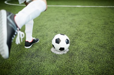 Yeşil sahada futbol maçı sırasında futbol topu tekmeleme önce futbolcu ayağı
