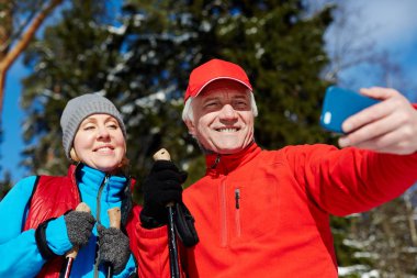 Mutlu üst düzey çift onların kış spor ormanda eğitim sırasında selfie yapma