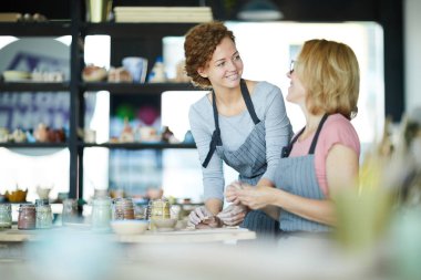 Çalışma sürecinin ayrıntılarını tartışırken kil zanaat onu koç bakarak Pretty genç stajyer