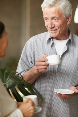 Çay ya da kahve bir fincan ile kıdemli adam kafede kahve-break karısıyla konuşuyor