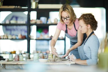 Kendinden emin usta veya kil zanaat koçu nasıl toprak öğeleri oluşturmak için onu stajyer söylüyorum
