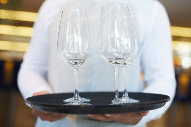 Garsonun yakın çekim restoranında boş şarap kadehleri servis edilmektedir