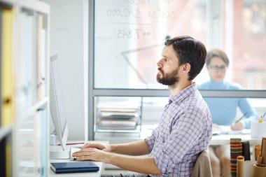 Veri girerken veya net web sitelerini ararken bilgisayar ekranına bakan ciddi yönetici veya tasarımcı