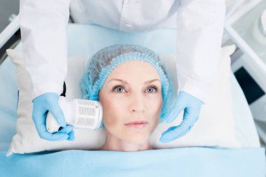 Güzellik salonunda özel elektrikli cihaz ile yüzüne masaj keyfi Olgun kadın