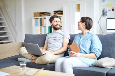 Neşeli genç çift online bilet rezerve etmeden önce tatil için nereye gitmek için tartışıyor