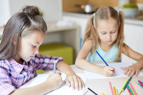 Due Ragazze Carine Sedute Alla Scrivania Disegnare Immagini Con Pastelli — Foto Stock