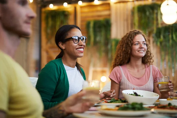 两个快乐的跨文化女孩坐在服务的节日餐桌在晚餐和交谈 — 图库照片