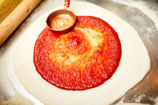 Baker Extendiendo Ketchup Tomate Encima Masa Enrollada Mientras Prepara Pizza — Foto de Stock