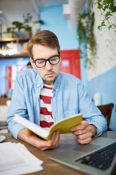 Young Analyst Economist Sitting Table Cafe Laptop Front Reading Book — Stock Photo, Image