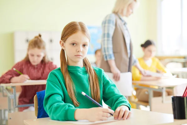 Allvarlig Trygg Skolflicka Med Rött Hår Sitter Vid Bordet Och — Stockfoto