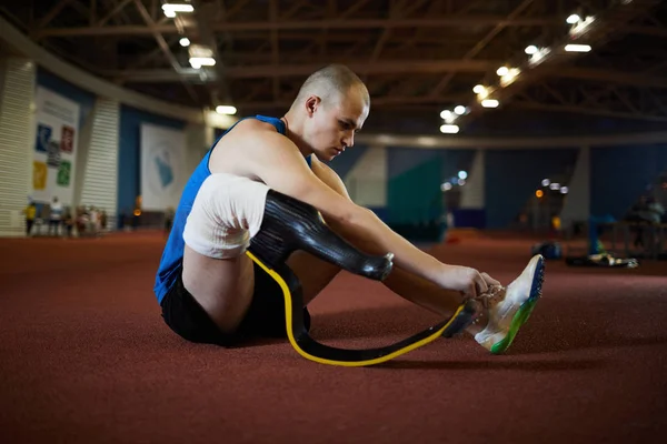 Активный Человек Искусственной Правой Ногой Завязывающий Шнурок Сидя Полу Современного — стоковое фото