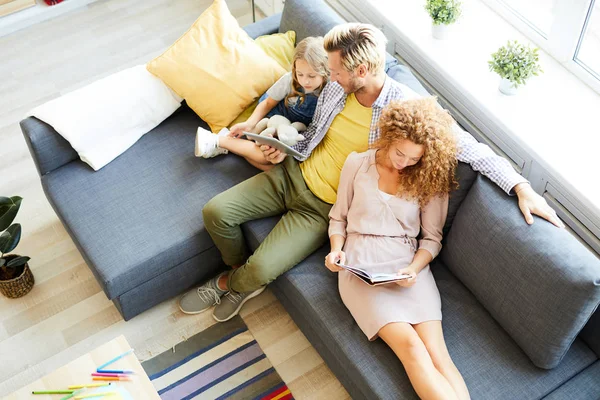 Visão Geral Família Relaxada Três Pessoas Sentadas Sofá Lendo Assistindo — Fotografia de Stock