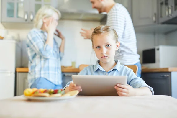 Menina Infeliz Com Touchpad Olhando Para Câmera Enquanto Seus Pais — Fotografia de Stock