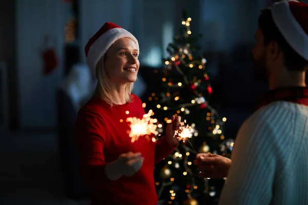 Junges Verliebtes Paar Mit Bengalischen Lichtern Die Sich Weihnachtsbaum Anschauen — Stockfoto