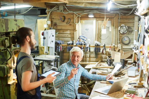 Senior Man Met Papier Zijn Jonge Collega Met Touchpad Met — Stockfoto