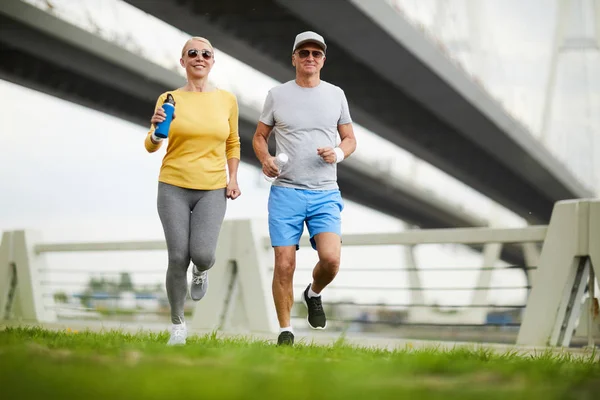 Happy Active Aged Couple Sportswear Running Green Lawn Urban Environment — Stock Photo, Image