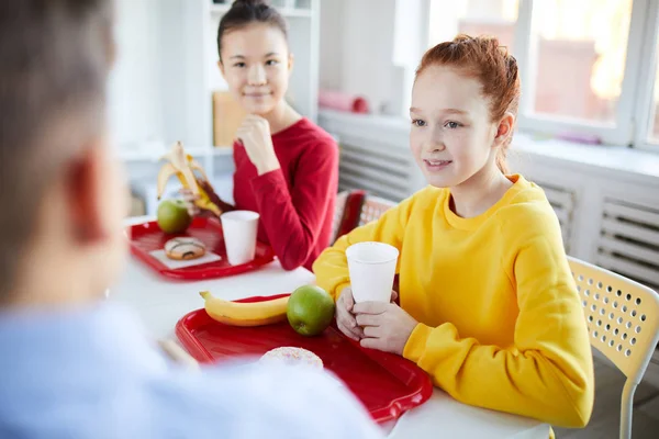 两个女学生在午休时与同学交谈 同时喝酒和吃水果零食 — 图库照片