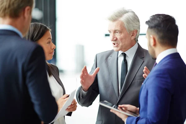 Selbstbewusster Grauhaariger Geschäftsmann Der Seinen Untergebenen Vor Geschäftskonferenzen Arbeitsmomente Erklärt — Stockfoto