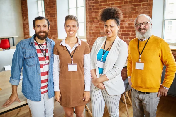 Four Successful Office Managers Badges Standing Front Camera Looking You — Stock Photo, Image