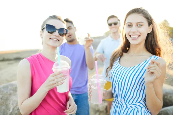 Dvě Hezké Dívky Drinky Klukama Pozadí Venku — Stock fotografie