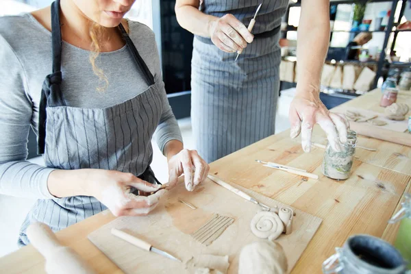 土の器を作る前にテーブルに座って粘土を作る若い女性 — ストック写真