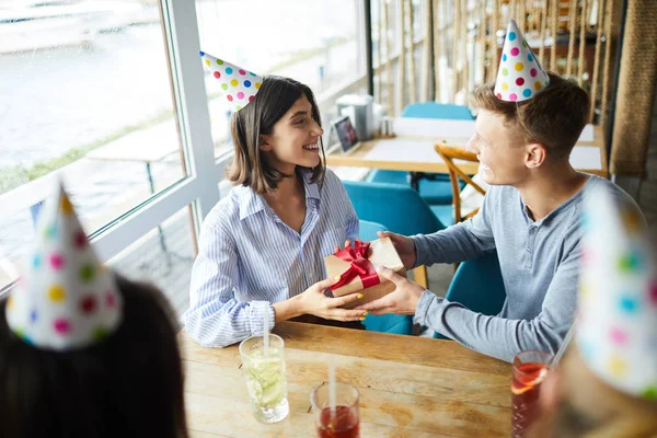 快乐的家伙祝贺他的女朋友的生日 而坐在咖啡馆与朋友 — 图库照片