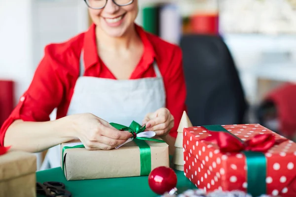Young Designer Tying Ribbon Top Package Xmas Gift While Working — Stock Photo, Image