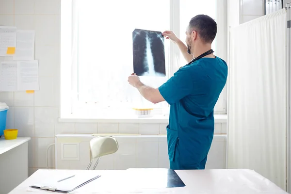 现代兽医穿着制服在办公室工作时 看着脊髓的X射线图像 — 图库照片
