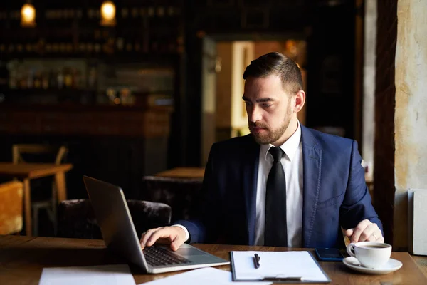 Ocupado Hombre Concentrado Traje Formal Usando Portátil Mientras Revisa Archivo — Foto de Stock