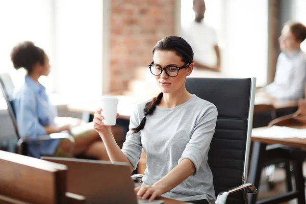 Ung Casual Affärskvinna Sitter Vid Skrivbordet Med Laptop Och Dricka — Stockfoto