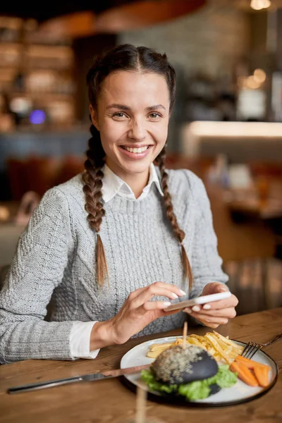 Chica Feliz Ropa Casualwear Mirándote Mientras Está Sentado Junto Mesa — Foto de Stock