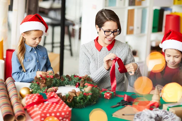 Happy Woman Rolling Red Silk Ribbon While Her Daughters Making — Stock Photo, Image