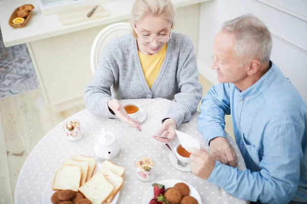 Esposa Sênior Mostrando Foto Marido Alguém Durante Café Manhã Cozinha — Fotografia de Stock