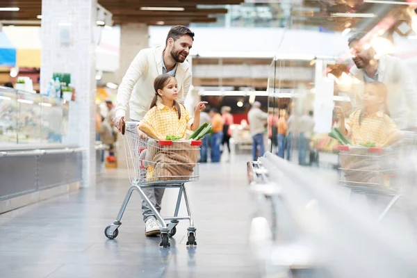 Serious Cute Girl Sitting Shopping Cart Pointing Finger Shelf While — Stock Photo, Image