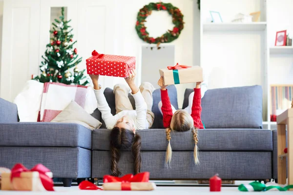 Två Små Flickor Liggande Soffan Och Hålla Giftboxes Medan Stretching — Stockfoto