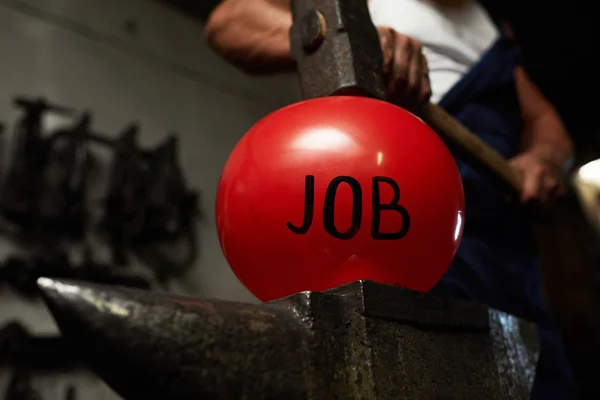 仕事を象徴する赤い膨らんだボールに重いハンマーを保つ鍛冶屋 — ストック写真