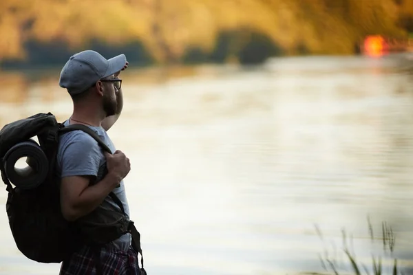 Jonge Backpacker Staat Aan Waterkant Bewondert Zonsondergang Natuurlijke Omgeving — Stockfoto