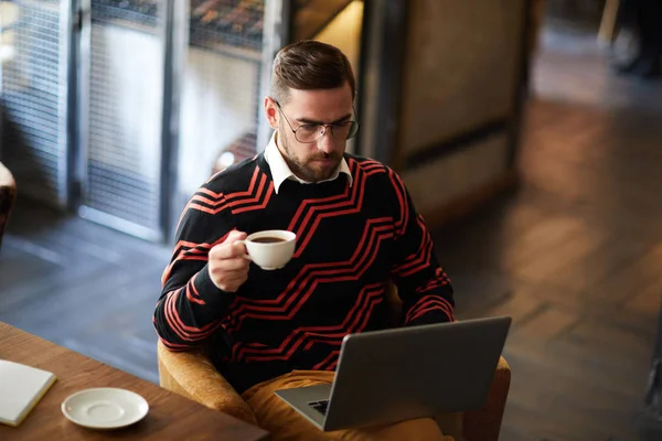 Ung Man Med Kopp Kaffe Koncentrerar Sig Nätverk Medan Sitter — Stockfoto