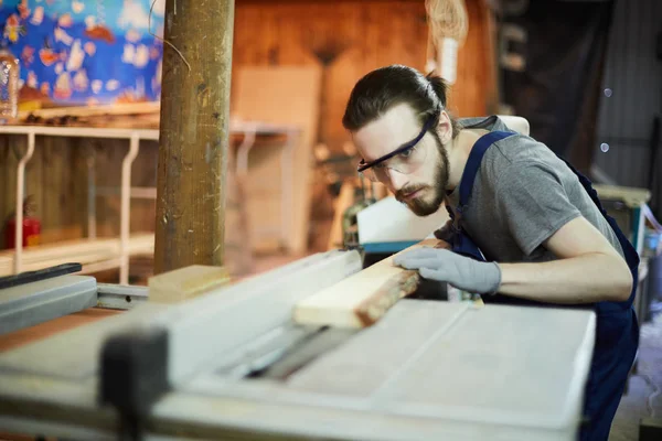 Junger Mann Steckt Holzbrett Während Der Arbeit Holzverarbeitungsmaschine — Stockfoto